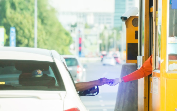 Uomo che paga al casello autostradale
