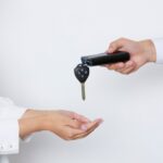 Uomo che da le chiavi dell'auto ad una donna: passaggio di proprietà