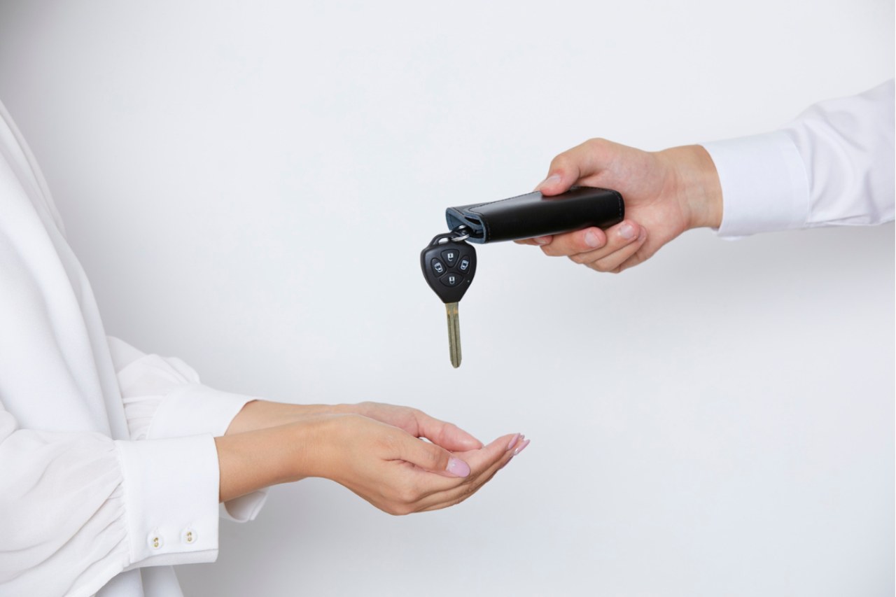 Uomo che da le chiavi dell'auto ad una donna: passaggio di proprietà