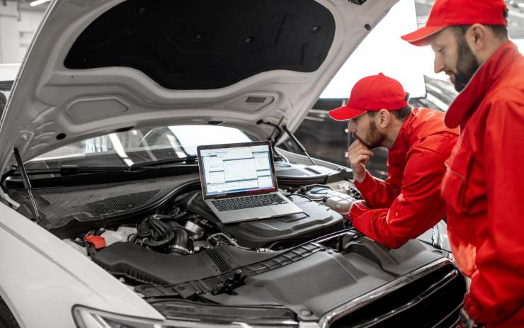 Due meccanici che fanno la revisione con pc ad un'auto