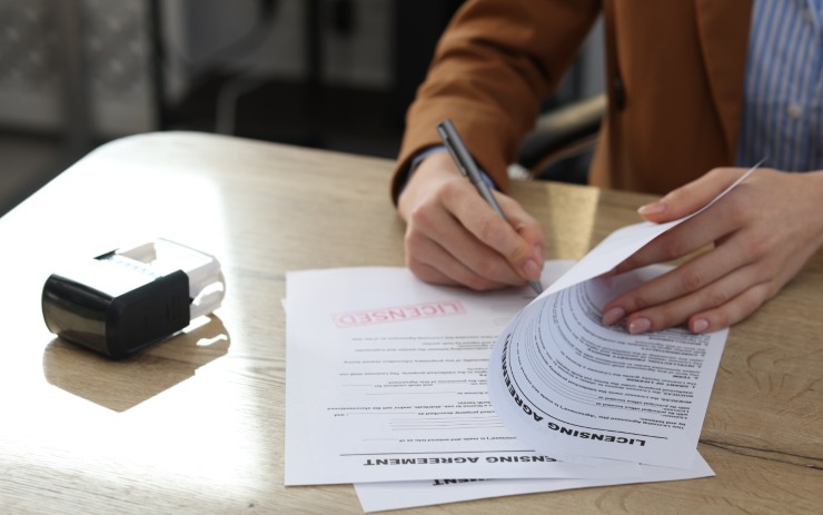Uomo che firma la pratica di rinnovo della patente