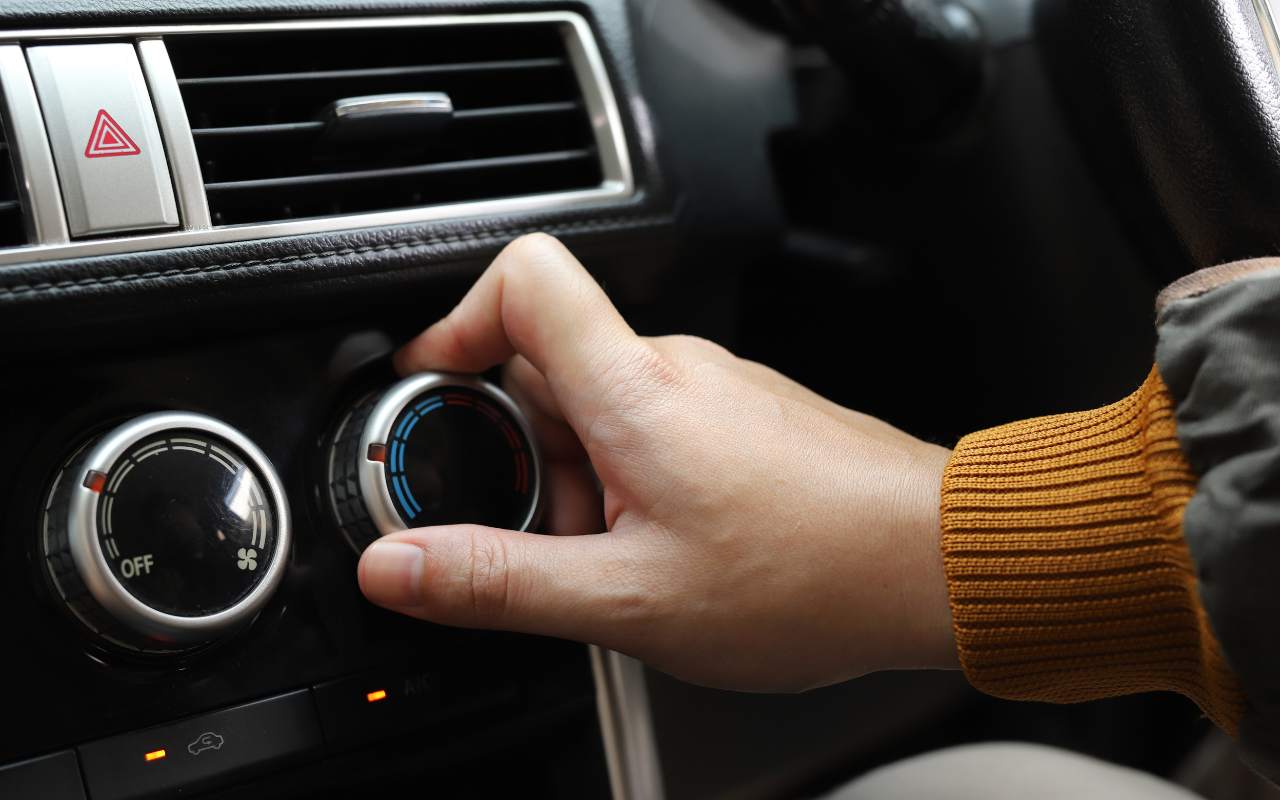 Persona che accende il riscaldamento in auto
