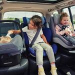 Tre bambini in auto sui rispettivi seggiolini