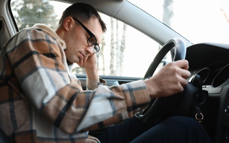 Ragazzo che si è addormentato con il volante dell'auto in mano