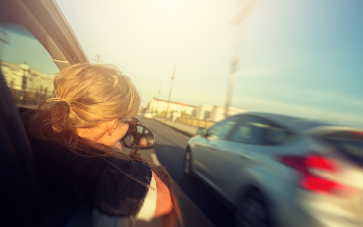 Donna lato passeggero affacciata al finestrino che guarda l'auto nella corsia di destra
