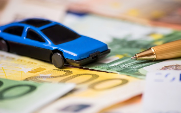 auto giocattolo sopra a banconote euro