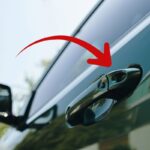Portiera auto e freccia che indica la maniglia