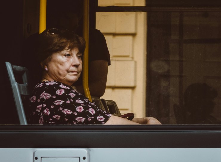 Donna over 65 sul bus che guarda dal finestrino
